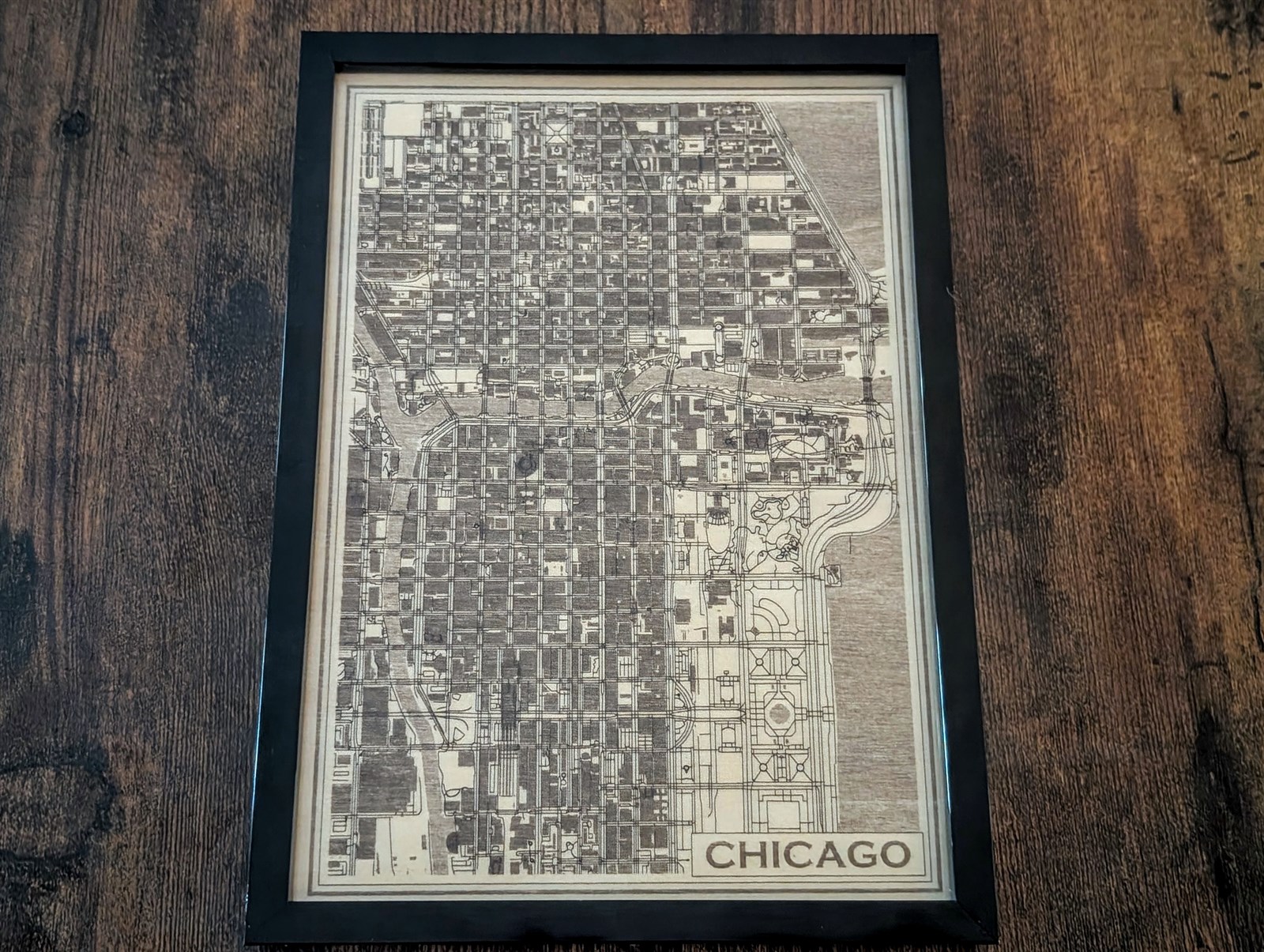 Finished Chicago map engraved on wood and displayed in a black frame